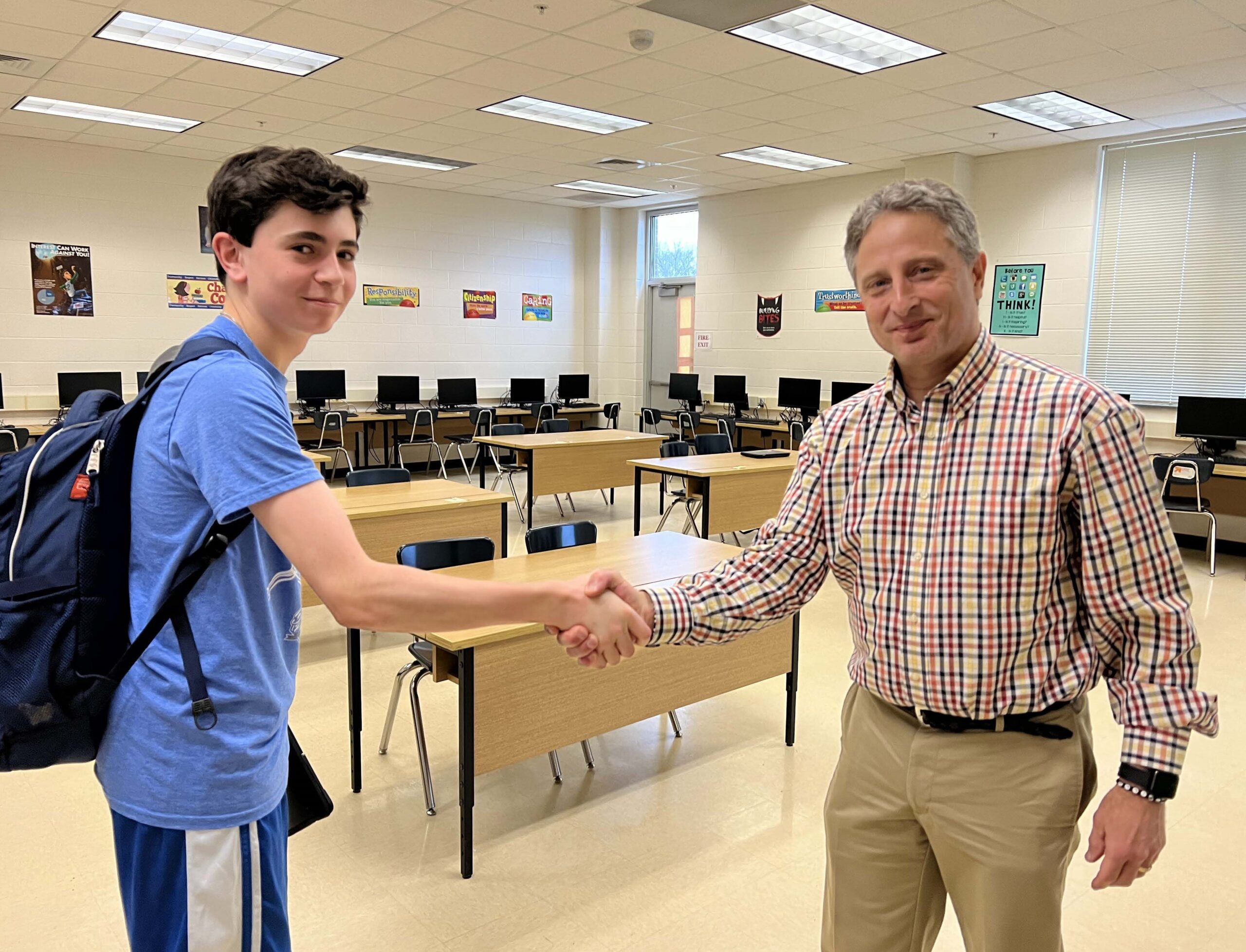 Student and adult shaking hands