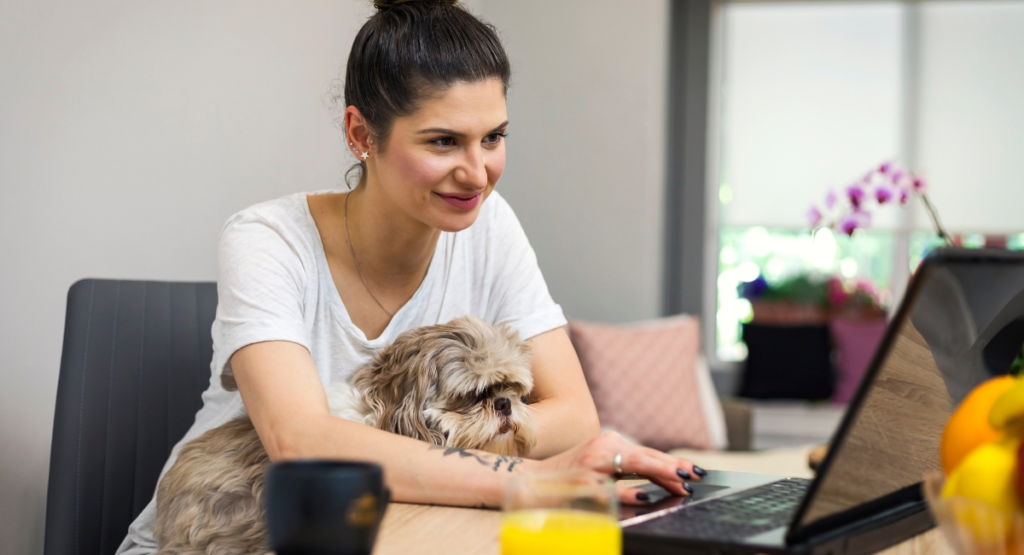 Lady working from home with dog on her lap