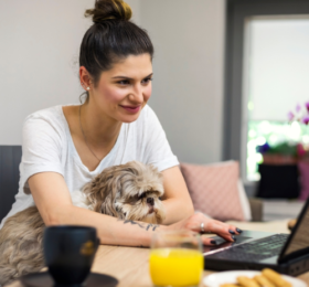 Lady working from home with dog on her lap
