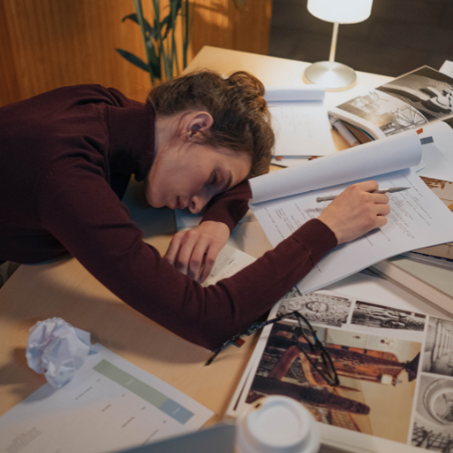 Woman sleeping on top of paperwork