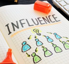 Notebook with the word "Influence" on it and drawing of people