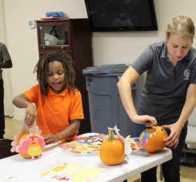 Woman and child decorating pumpkins
