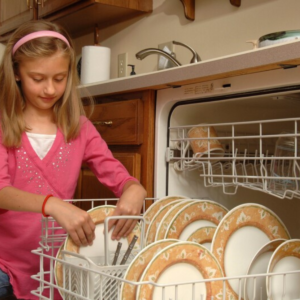 Young girl loading dishwasher