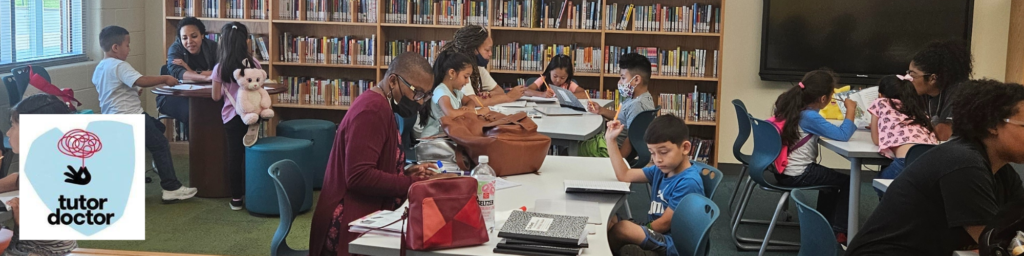 Students in a library with tutors teaching them