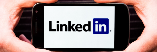 Hands holding cell phone with LinkedIn logo
